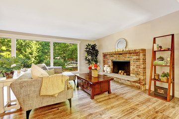 Spacious bright living room with glass wall and brick fireplace