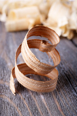 Wood shavings on grey wooden background closeup