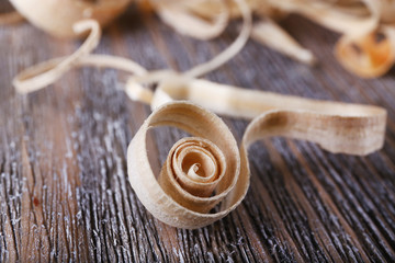 Wood shavings on grey wooden background closeup