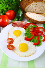 Scrambled eggs with bacon and vegetables served