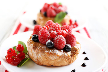 Sweet cakes with berries on table close-up