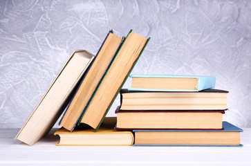 Books on wooden table on light background