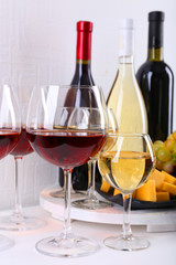 Bottles and glasses of wine, cheese and ripe grapes