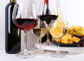 Bottles and glasses of wine, cheese and ripe grapes