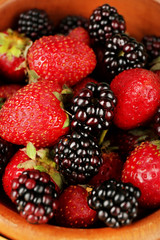 Strawberries and blackberries in bowl close up