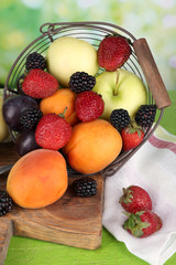 Ripe fruits and berries on table on bright background