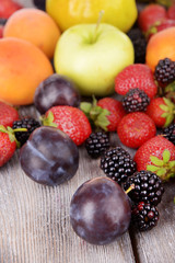 Ripe fruits and berries on wooden background