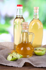 Apple cider vinegar in glass bottles and ripe fresh apples,