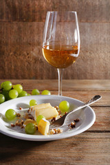 beautiful still life with wine, cheese and ripe grape