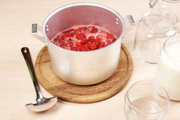 Cooking delicious strawberry jam in kitchen