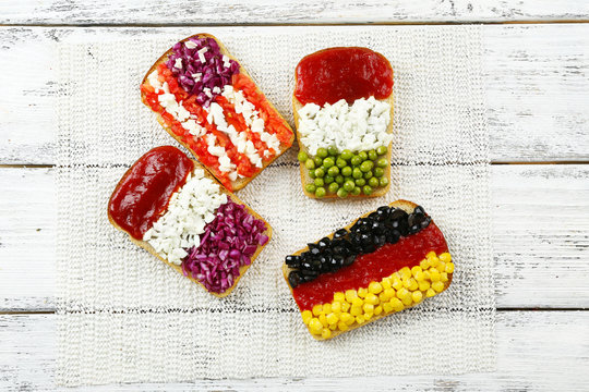 Sandwiches with  different flags on table close-up