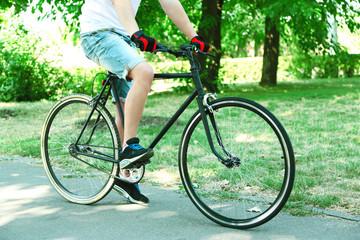 Fototapeta na wymiar Man biking fast in city park. View from bikers eyes