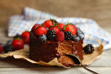 Tasty chocolate cake with different berries on wooden table
