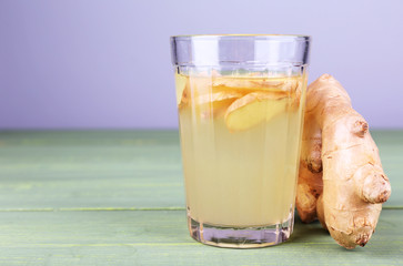 Ginger drink on wooden table on light background