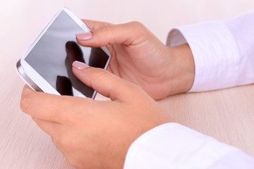 Woman using smartphone on light background