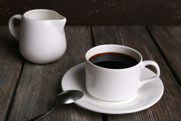 Cup of coffee and cream in milk jug