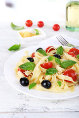Spaghetti with tomatoes, olives and basil leaves