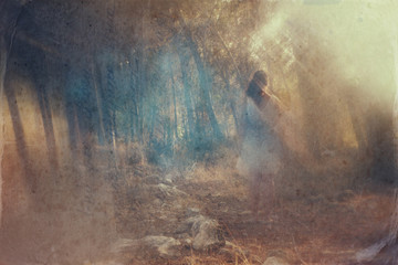 surreal blurred background of young woman stands in forest. abst