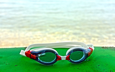 Blue and red goggles by the sea