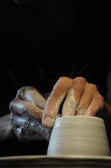 hands of a potter, creating an earthen jar on the circle