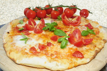 Pizza margherita con pomodorini su tagliere