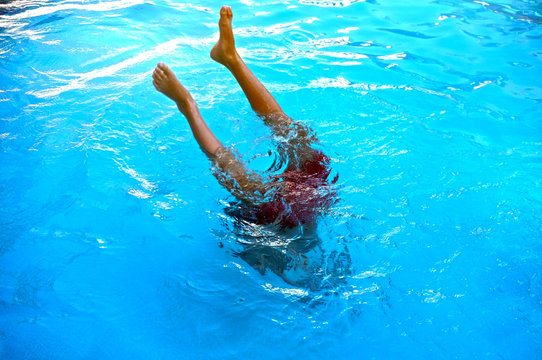 Young teenage boy diving to pool