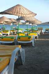 Empty beach with parasols and deck chairs