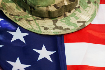 US flag with camouflage combat hat