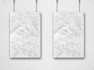 two hanging crumpled lists of paper and wall background