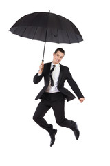 Jumping businessman with an umbrella