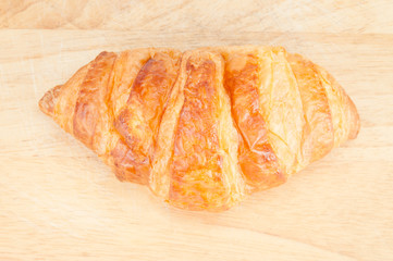 Fresh homemade croissants on wooden table.