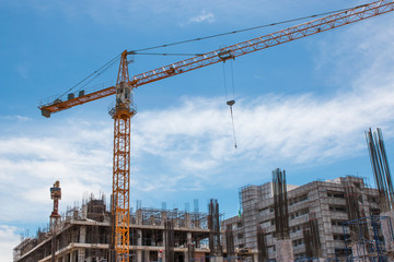 building and crane under construction against blue sky