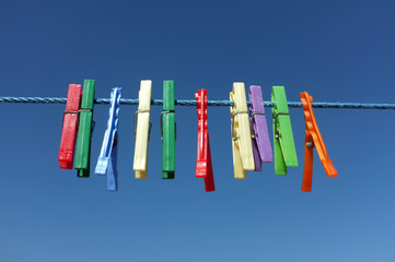Multicolored clothespin hanged on a blue cord - 70445829