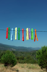 Fototapeta na wymiar Multicolored clothespin hanged on a blue cord