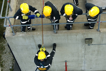 fire fighters abseiling down building
