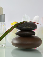 bottles of essential oil and set  stones with flower