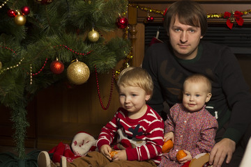 Fototapeta na wymiar Happy family with baby under decorated Christmas Tree, gifts