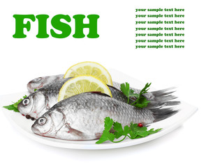 Fresh fishes with lemon and parsley on plate isolated on white