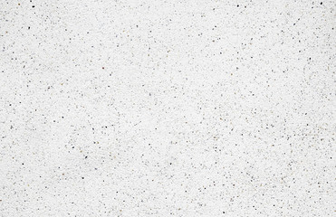 White cement wall with tiny rock on surface, grunge background.
