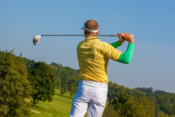 	Man playing golf against blue sky