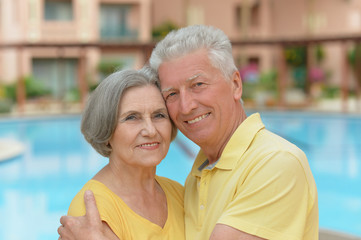Senior couple standing by pool