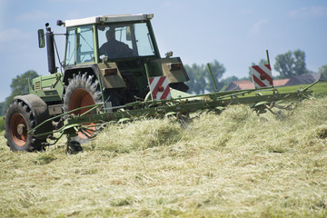 landwirt beim heu umwälzen