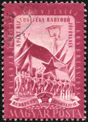 stamp shows worker, peasant and student and flags