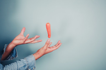 Young man making a carrot levitate