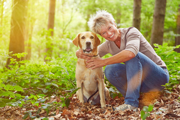 Ältere Frau mit Hund im Wald