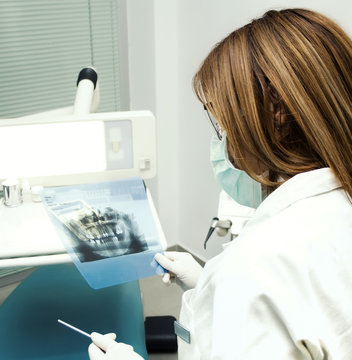 Dentist looking at X-ray of teeth and gums