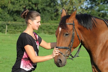 junge Frau beruhigt ihr Pferd