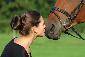 Junge Frau küsst ihr Pferd