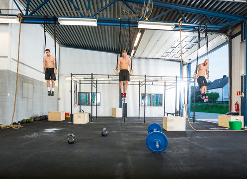 Athletes Exercising On Gymnastic Rings