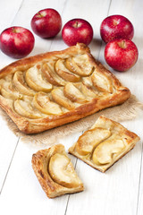 Fresh slice of apple pie with whole pie in background